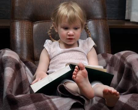 65750634-little-girl-with-a-large-book-green-book-the-girl-in-the-chair-a-girl-with-two-braids-wearing-a-whit